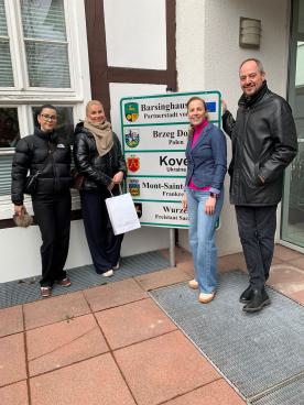 Thorsten Franz (KGS) mit drei Lehrerinnen aus Brzeg Dolny vor dem Rathaus am Schild der Städtepartnerschaften