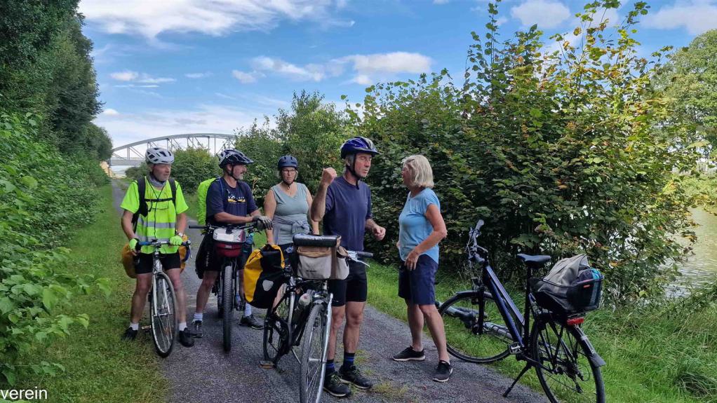 Eine Gruppe Radfahrer steht auf dem Radweg am Rand des Mittellandkanals