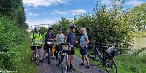 Eine Gruppe Radfahrer steht auf dem Radweg am Rand des Mittellandkanals