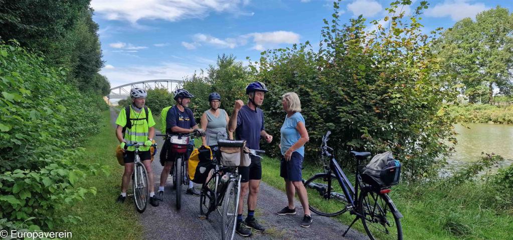 Eine Gruppe Radfahrer steht auf dem Radweg am Rand des Mittellandkanals