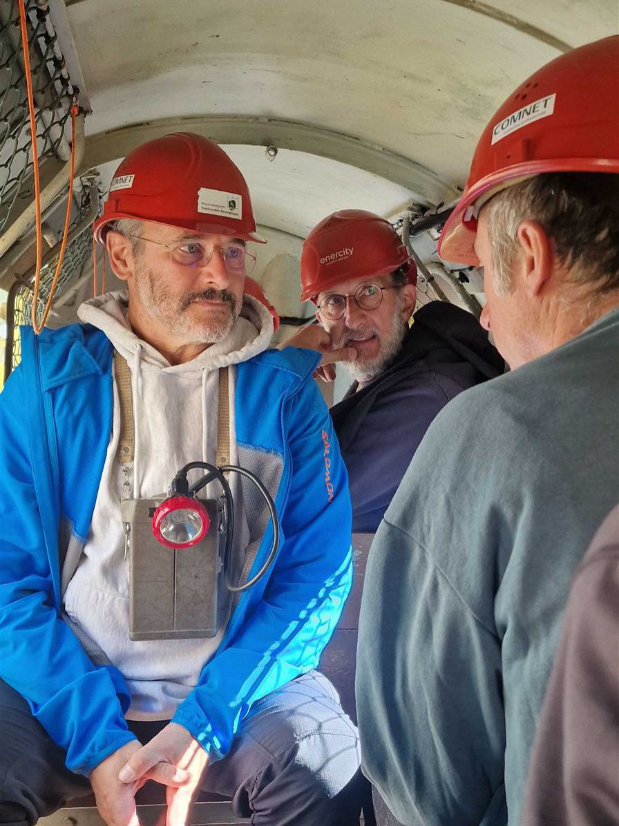 Drei Männer unterhalten sich während einer Fahrt mit dem Grubenzug