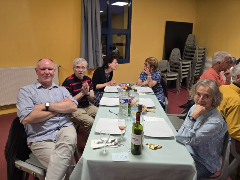 Eine Gruppe sitzt zum Essen an einem Tisch