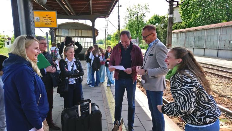 Das Foto zeigt die Lehrkräfte auf einem Bahnsteig bei der Verabschiedung durch den Bürgermeister. Im Hintergrund sind die Schüler*innen.